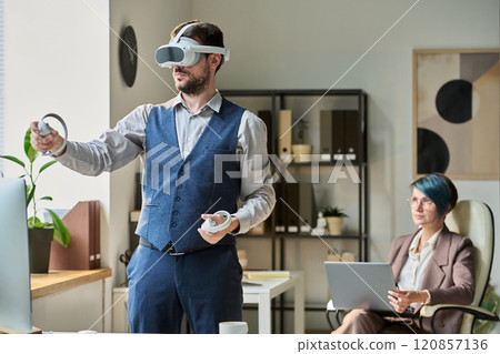 Man with VR headset using controllers Man with VR headset using controllers 120857136