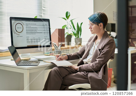 Serious young analyst taking notes Serious young analyst taking notes 120857166