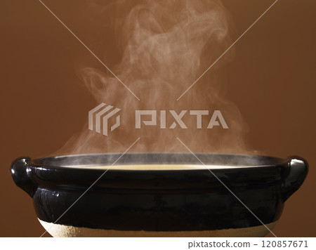 Image of hot pot cooking with steam rising from the clay pot Image of hot pot cooking with steam rising from the clay pot 120857671