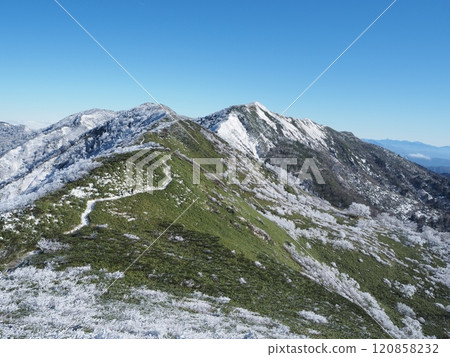 Climbers walking along a ridge covered in frost 3 Climbers walking along a ridge covered in frost 3 120858232