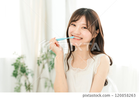 Young asian woman brushing her teeth at home 120858263
