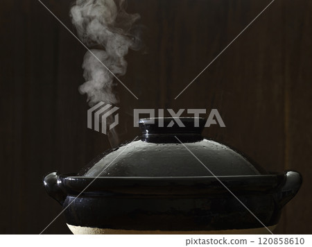 Image of hot pot cooking with steam rising from the clay pot Image of hot pot cooking with steam rising from the clay pot 120858610