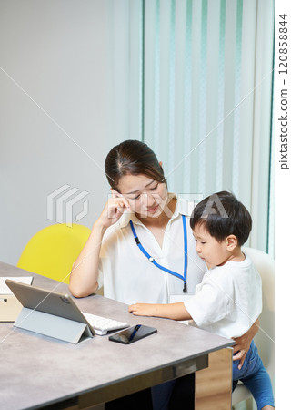 一邊工作一邊帶孩子的女人 一邊工作一邊帶孩子的女人 120858844