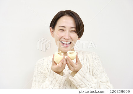 女人打破肉包子，白色背景，看著相機 120859609