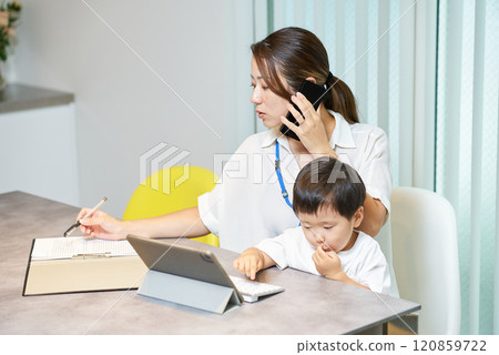 一位女士在工作時抱著孩子打電話 120859722