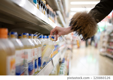 Woman's hands choosing cooking oil 120860126