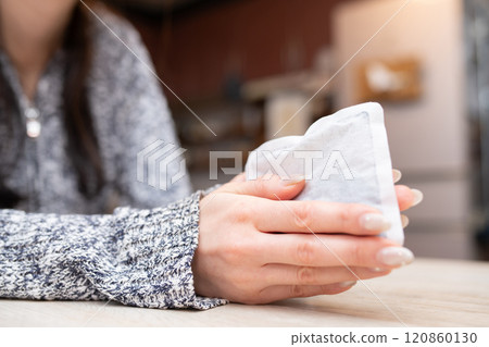 Woman's hand holding a disposable hand warmer 120860130