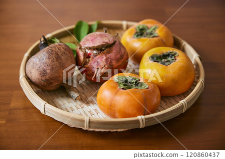 Persimmons and pomegranates served in a colander Persimmons and pomegranates served in a colander 120860437