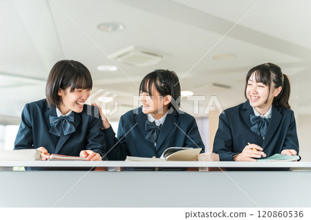 Elementary school students, junior high school students, high school students, and high school girls (friends) in uniforms talking happily during class in a school classroom Elementary school students, junior high school students, high school students, and high school girls (friends) in uniforms talking happily during class in a school classroom 120860536