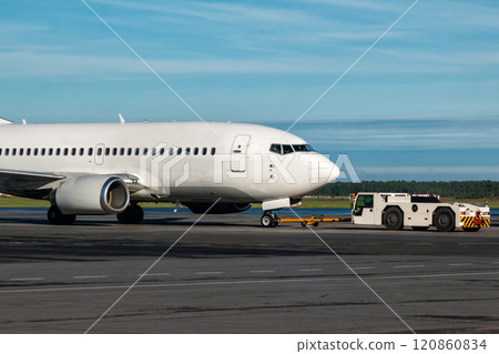 The tractor is towing the passenger airplane The tractor is towing the passenger airplane 120860834