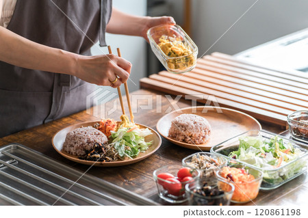 A housewife serving a one-plate lunch in the kitchen A housewife serving a one-plate lunch in the kitchen 120861198