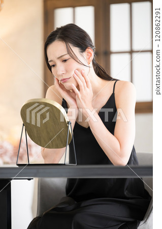 一位女士在睡前在黃光下護理皮膚的特寫鏡頭，擔心照顧自己的口腔和皮膚。 120862291