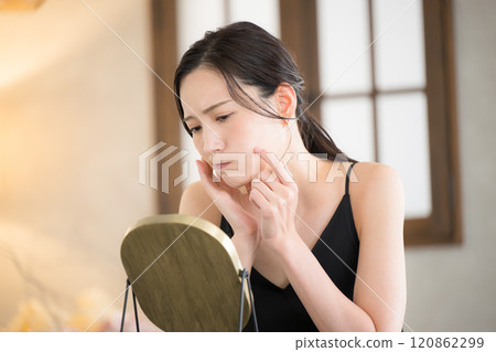 Woman doing skin care before going to bed with yellow light Close-up Thinking and worrying about caring for her mouth and skin 120862299