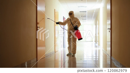 A man sprays a wall of a building from a balloon A man sprays a wall of a building from a balloon 120862979