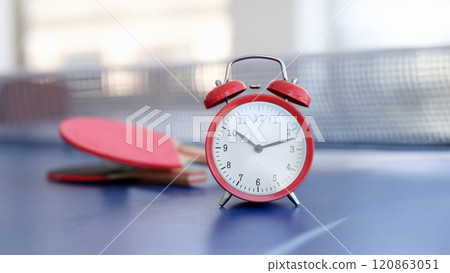 Red alarm clock on a tennis table, close-up 120863051