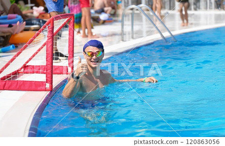 Sports man in the pool smiling and showing thumbs up 120863056