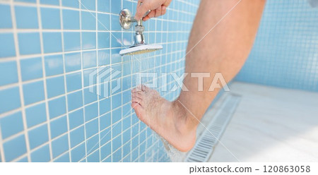 A man regulates the flow of water, washes foot in the shower A man regulates the flow of water, washes foot in the shower 120863058