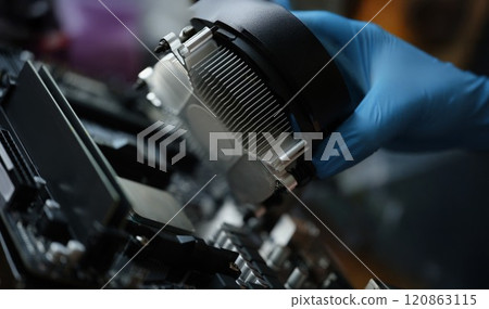 A hand in a glove installs a new cooler for a pc 120863115