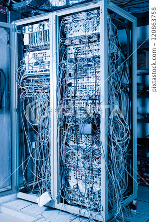 server room rack with tangled network cables creating messy unti 120863758