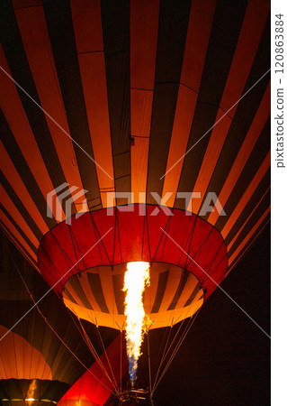 A Beautifully Illuminated Hot Air Balloon with a Majestic Flame Rising High into the Night Sky A Beautifully Illuminated Hot Air Balloon with a Majestic Flame Rising High into the Night Sky 120863884