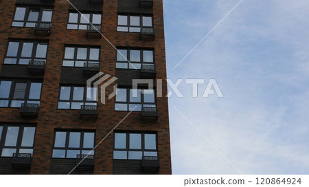 brown brick high rise building view from bottom to top against light blue sky, architectural background with modern residential building brown brick high rise building view from bottom to top against light blue sky, architectural background with modern residential building 120864924