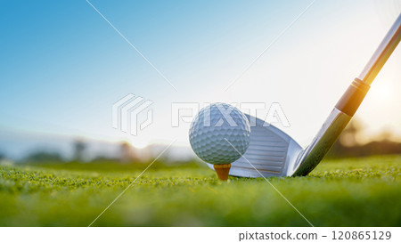 Golf clubs and golf balls on a green lawn in a beautiful golf course with morning sunshine. 120865129
