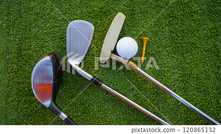 Golf clubs and golf balls on a green lawn in a beautiful golf course with morning sunshine. 120865132