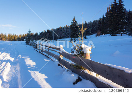 countryside landscape in winter. wooden fence through snow covered hill 120866543