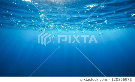 Underwater tranquility with sunbeams piercing through sea surface to ocean depths, bubbles, clear blue waters, sunlight creating ethereal underwater patterns, perfect for natural aquatic background Underwater tranquility with sunbeams piercing through sea surface to ocean depths, bubbles, clear blue waters, sunlight creating ethereal underwater patterns, perfect for natural aquatic background 120866978