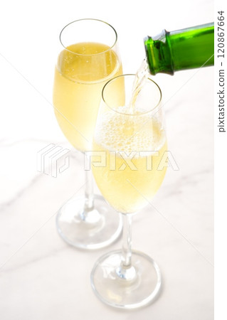Pour well-chilled champagne (sparkling wine) into a flute glass Pour well-chilled champagne (sparkling wine) into a flute glass 120867664