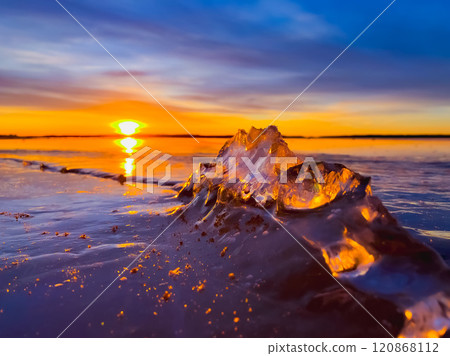Frosty air and frozen lake surface in a beautiful sunset landscape. Beautiful ice shapes and sunlight. Photo from Sotkamo, Finland. 120868112