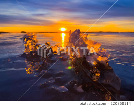 Frosty air and frozen lake surface in a beautiful sunset landscape. Beautiful ice shapes and sunlight. Photo from Sotkamo, Finland. Frosty air and frozen lake surface in a beautiful sunset landscape. Beautiful ice shapes and sunlight. Photo from Sotkamo, Finland. 120868114