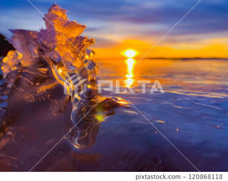 Frosty air and frozen lake surface in a beautiful sunset landscape. Beautiful ice shapes and sunlight. Photo from Sotkamo, Finland. 120868118