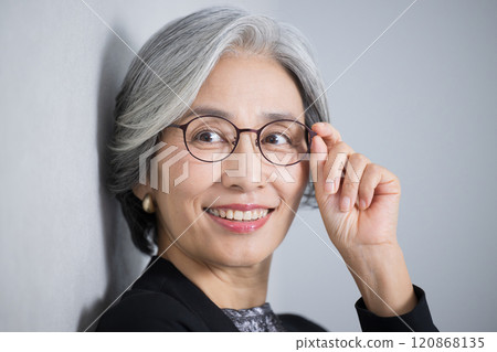 頭髮花白、穿著西裝、戴著眼鏡的高級女總裁的照片。 120868135