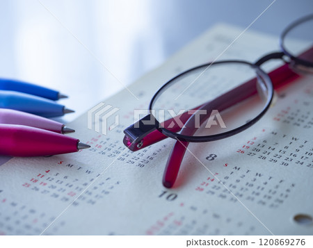 Calendar and glasses on a table Calendar and glasses on a table 120869276