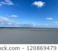 A quiet beach with a vast blue sky and sand 120869479