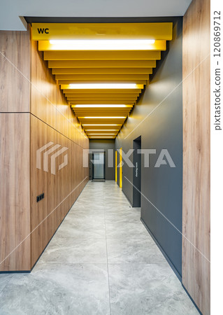 Perspective of a long corridor in office building. Doors of washrooms in hallway. Doors in office with wc signs. Entrance to restrooms in a factory Perspective of a long corridor in office building. Doors of washrooms in hallway. Doors in office with wc signs. Entrance to restrooms in a factory 120869712