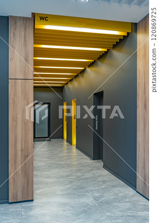 Perspective of a long corridor in office building. Doors of washrooms in hallway. Doors in office with wc signs. Entrance to restrooms in a factory Perspective of a long corridor in office building. Doors of washrooms in hallway. Doors in office with wc signs. Entrance to restrooms in a factory 120869725