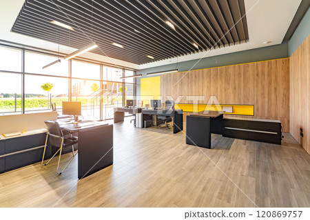 Modern office space with tables and chairs, computers and office supplies with no employees 120869757