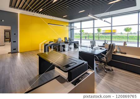 Modern office space with tables and chairs, computers and office supplies with no employees Modern office space with tables and chairs, computers and office supplies with no employees 120869765