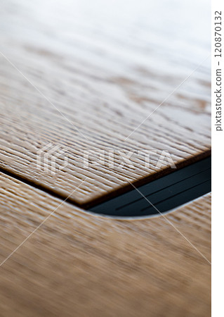 Mobile phone with wireless charger on table. Modern workplace accessory 120870132
