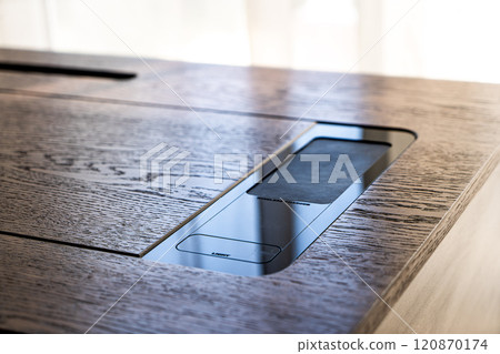 Mobile phone with wireless charger on table. Modern workplace accessory 120870174