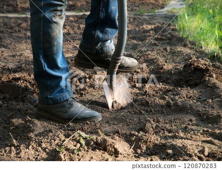 Man's feet with a shovel 120870283