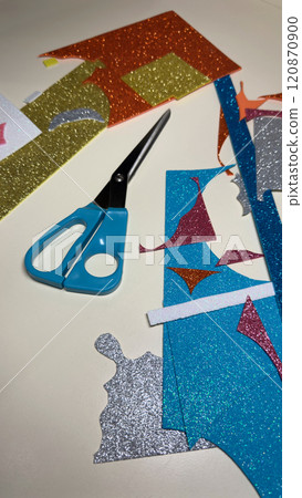 Vertical photo of table with cut pieces from sheets of multi colored foamiran 120870900