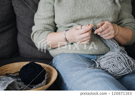 Pregnant woman knitting quietly on sofa, embracing self-care. Mindful crafting, relaxation, and slow living during pregnancy. Pregnant woman knitting quietly on sofa, embracing self-care. Mindful crafting, relaxation, and slow living during pregnancy. 120871163