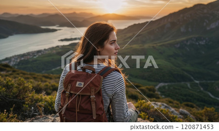 young woman with a backpack resting on a mountaintop 120871453