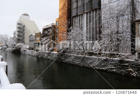 Snow-covered river running through the city 120871648