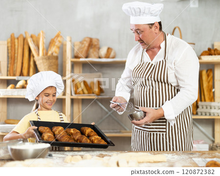 Surprised father looks at cooked croissants, rejoices at result of daughters work 120872382