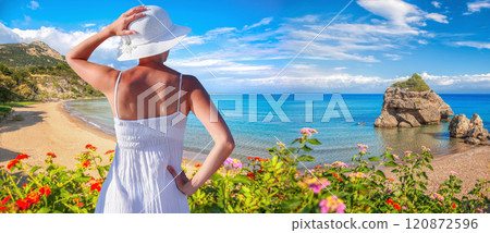 Beautiful woman in white summer dress stands on Porto Zorro beach, Zakynthos island, Greece Beautiful woman in white summer dress stands on Porto Zorro beach, Zakynthos island, Greece 120872596