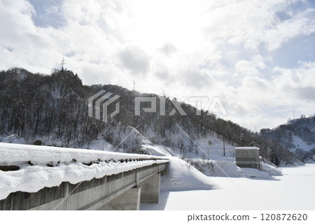 A view of a snow-covered bridge in Oguni Town on a sunny winter day when the sun is shining brightly 120872620